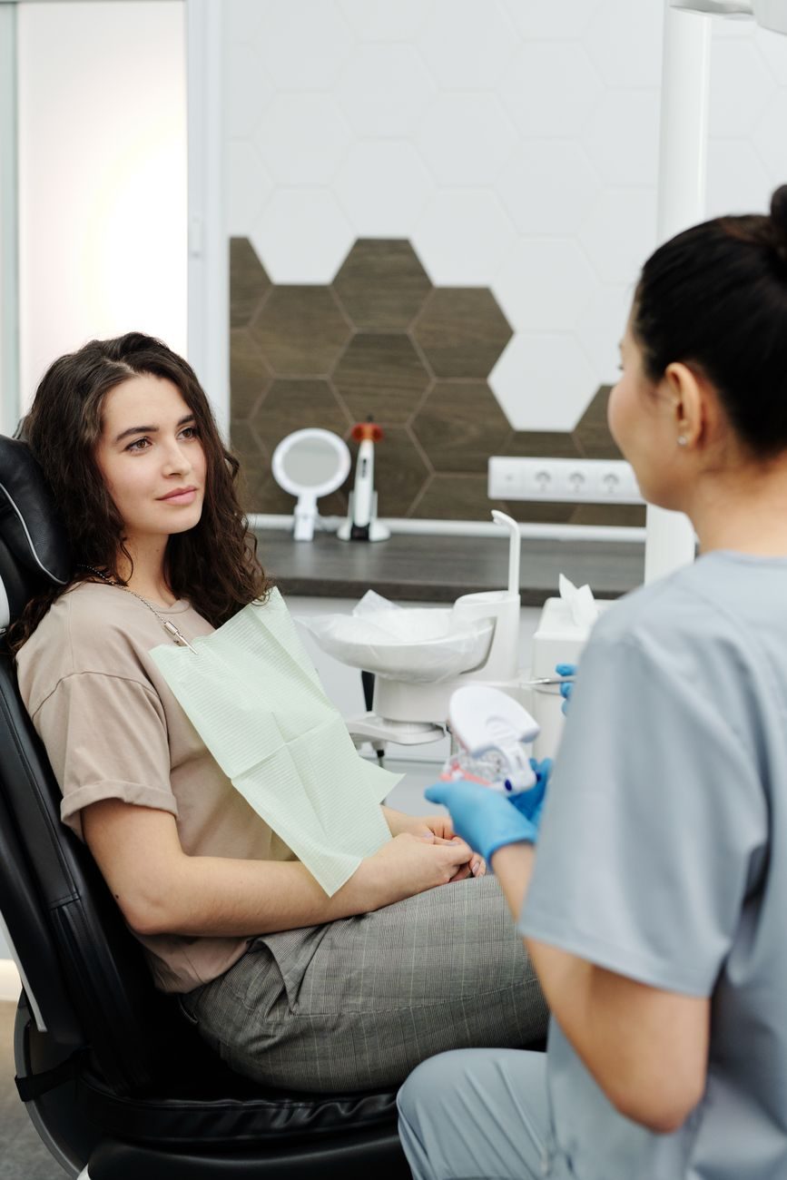 Smiling patient in a dentist's chair with the dentist beside her